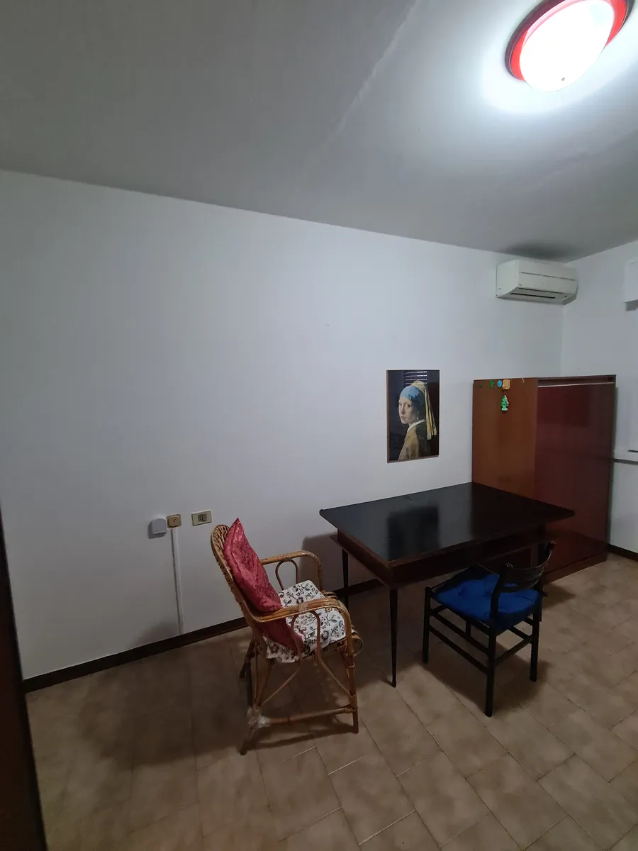 La stessa stanza prima, con il vecchio tavolo e le sedie ancora al centro