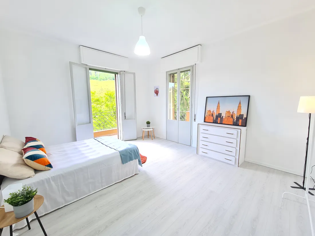 Camera luminosa con letto e cassettiera dopo gli interventi mirati