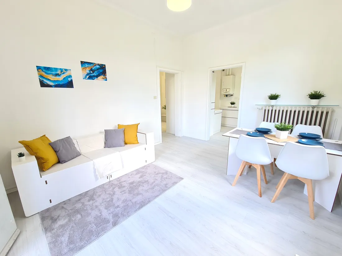 Soggiorno con divano bianco e tavolo dopo l'home staging