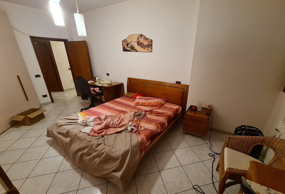 Camera da letto di via Misa prima dell'home staging, con arredo da rinnovare